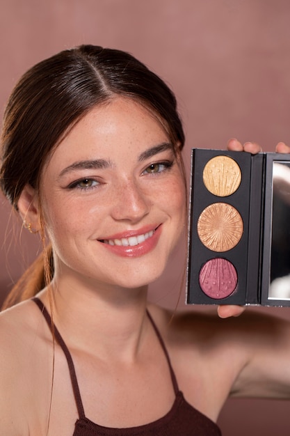 Foto gratuita retrato de mujer joven hermosa con un producto de maquillaje