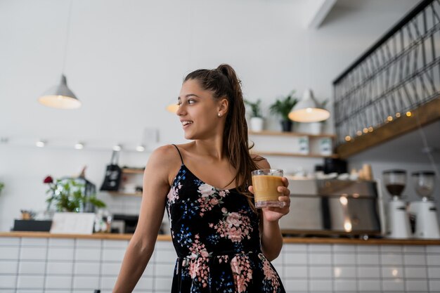 Retrato de mujer joven hermosa que va a tomar café