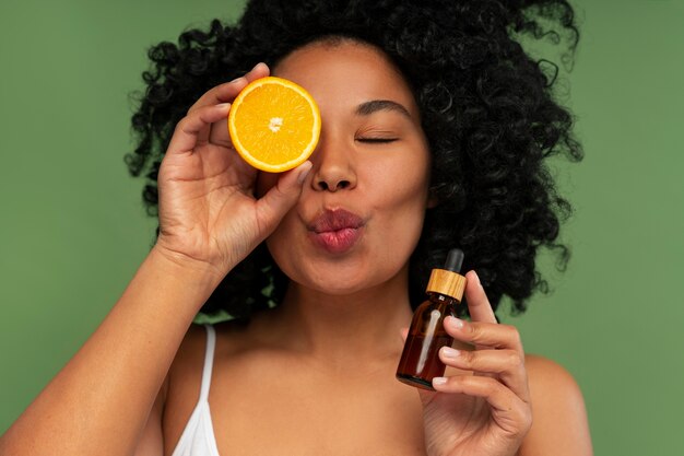 Retrato de mujer joven y hermosa con suero de cítricos y vitamina c