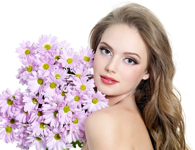 Retrato de mujer joven con hermosas flores de primavera en blanco