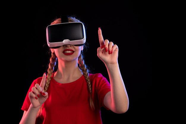 Retrato de mujer joven jugando realidad virtual en la pared oscura