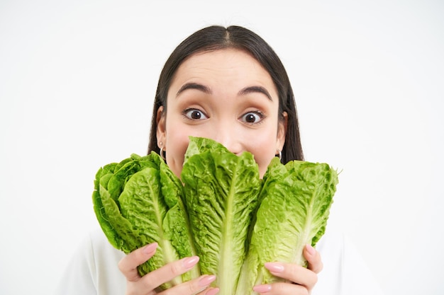 Foto gratuita retrato de mujer joven linda muestra su rostro con repollo le gusta verduras come saludable nutritivo di