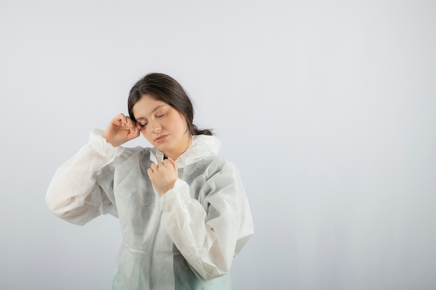 Retrato de mujer joven médico científico en bata de laboratorio defensiva posando.