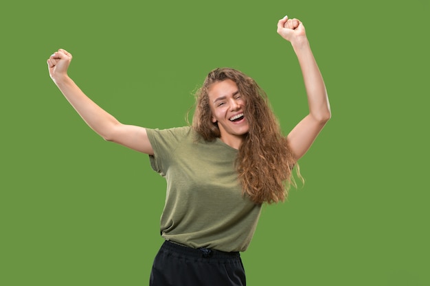 Retrato de mujer joven modelo bailando aislado en la pared verde