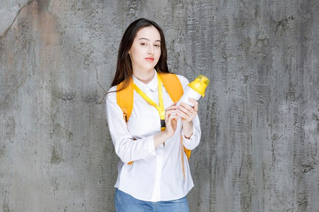 Retrato de mujer joven mostrando una botella de agua. foto de alta calidad