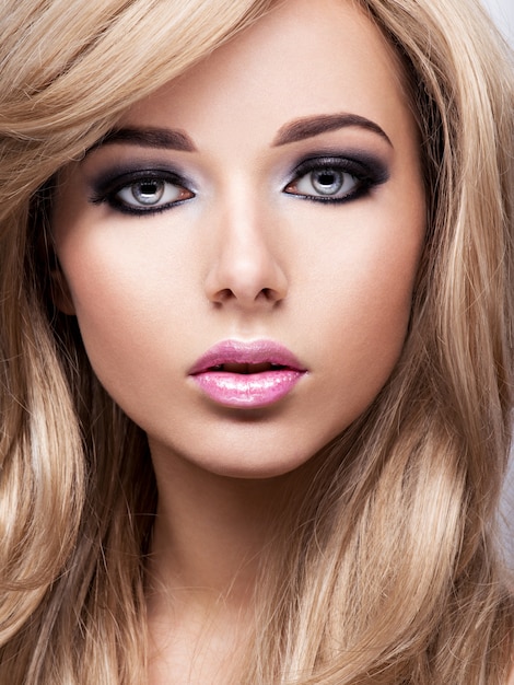 Retrato de mujer joven muy atractiva con maquillaje brillante. Hermoso cabello castaño.