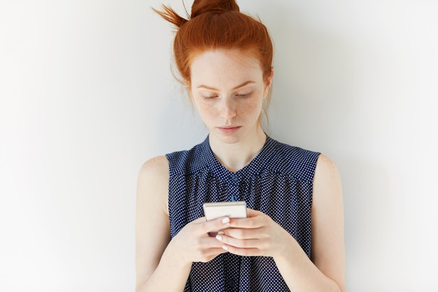 Foto gratuita retrato de mujer joven pelirroja sosteniendo teléfono