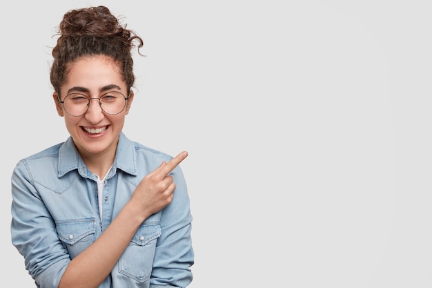 Foto gratuita retrato, de, mujer joven, con, pelo recogido, y, llevando, camisa vaquera