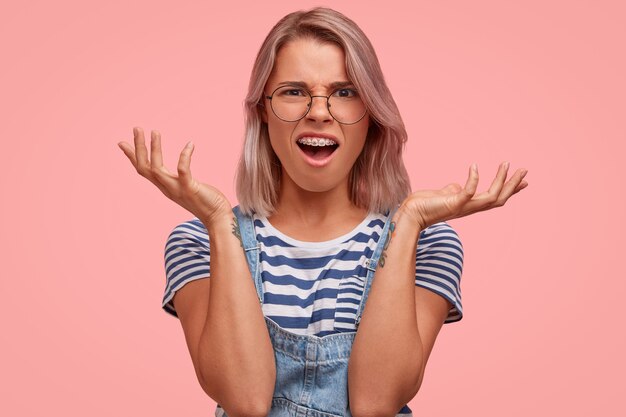 Retrato, de, mujer joven, con, pelo teñido, llevando, overoles