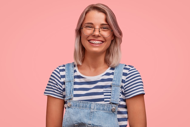 Retrato, de, mujer joven, con, pelo teñido, llevando, overoles