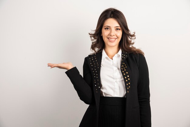 Retrato de mujer joven de pie sobre blanco.