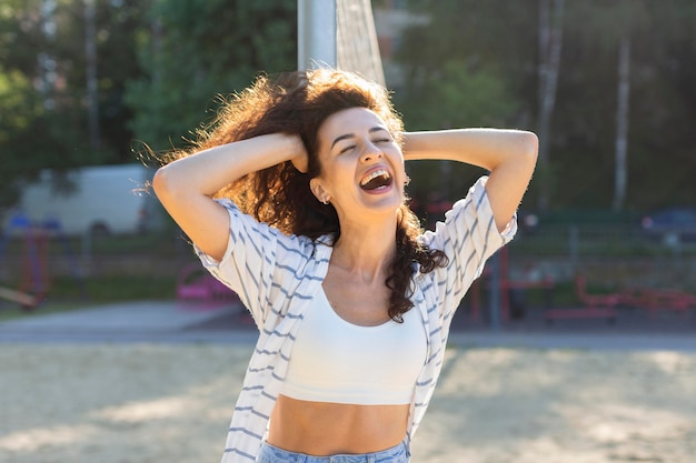 Foto gratuita retrato de mujer joven posando junto a un campo de voleibol fuera