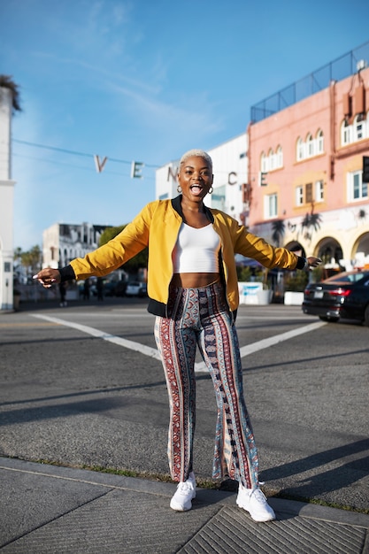 Foto gratuita retrato, de, un, mujer joven, posar, exterior, en la ciudad