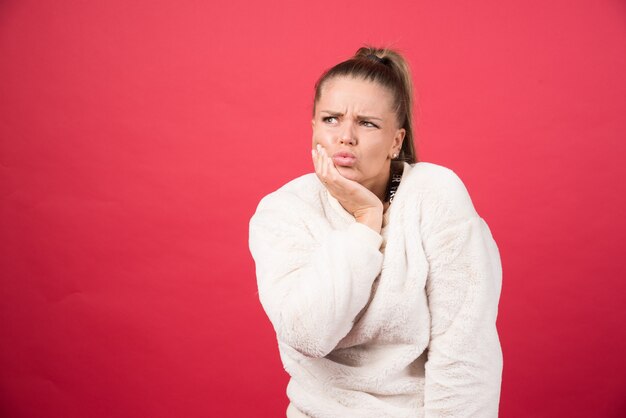 Retrato, de, un, mujer joven, posición, y, posar, en, un, pared roja