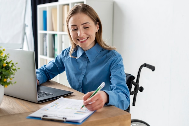 Foto gratuita retrato de mujer joven positiva trabajando en la oficina