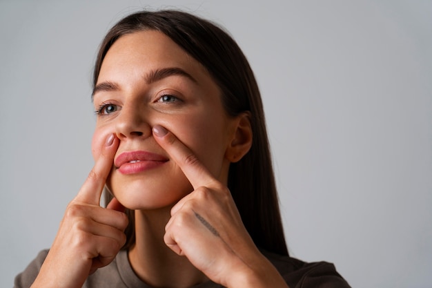 Retrato de mujer joven practicando yoga facial para jóvenes