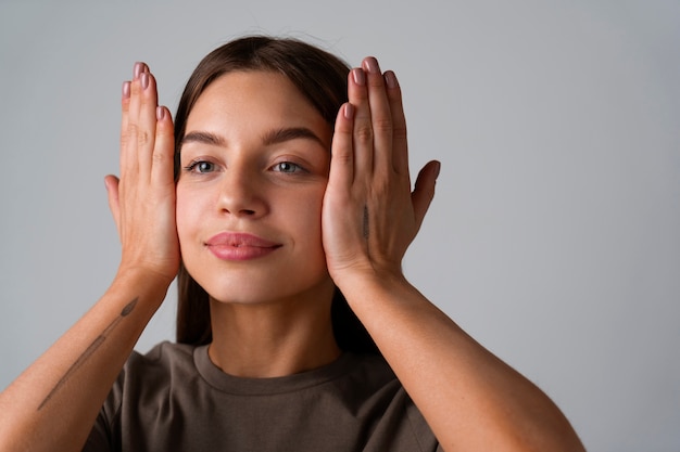 Foto gratuita retrato de mujer joven practicando yoga facial para jóvenes