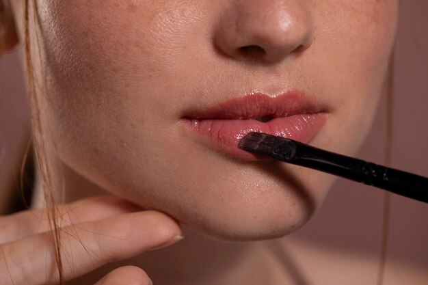 Retrato de mujer joven con un producto de maquillaje