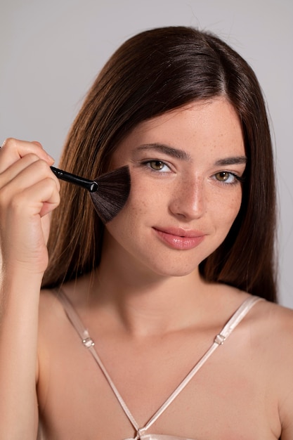 Retrato de mujer joven con un producto de maquillaje