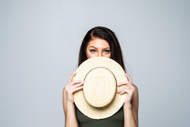 Retrato de mujer joven que cubre su rostro con sombrero de verano aislado.