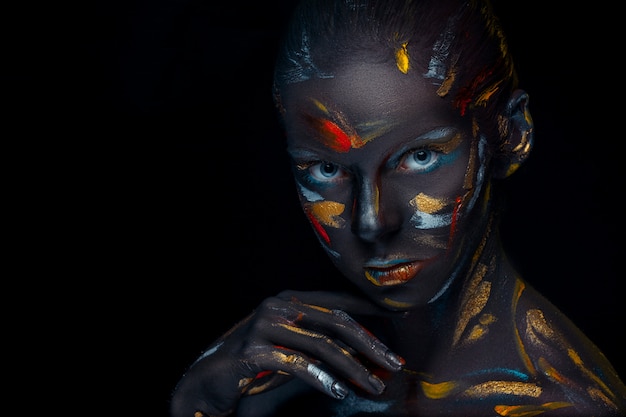 Retrato de una mujer joven que está posando cubierta con pintura negra