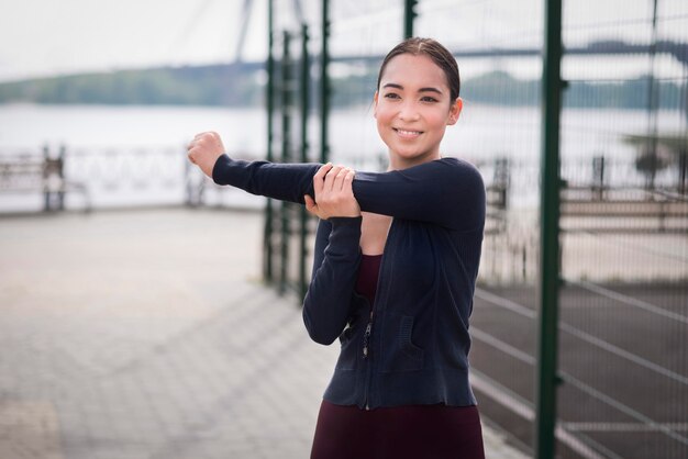 Retrato de mujer joven que se extiende al aire libre