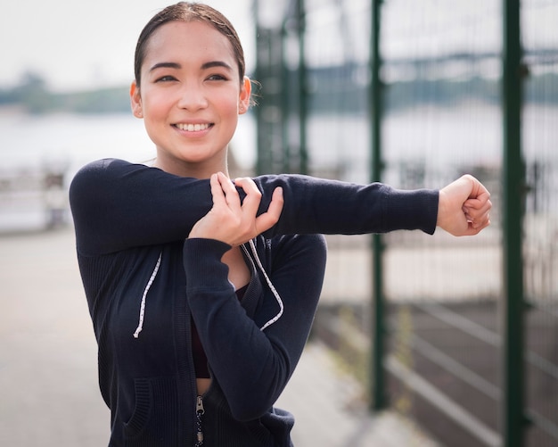 Retrato de mujer joven que se extiende al aire libre