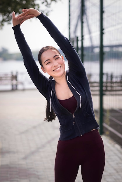 Foto gratuita retrato de mujer joven que se extiende al aire libre