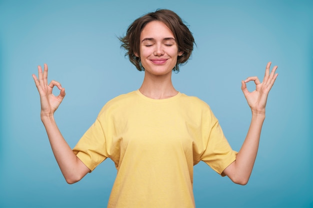 Retrato de una mujer joven que muestra el signo zen