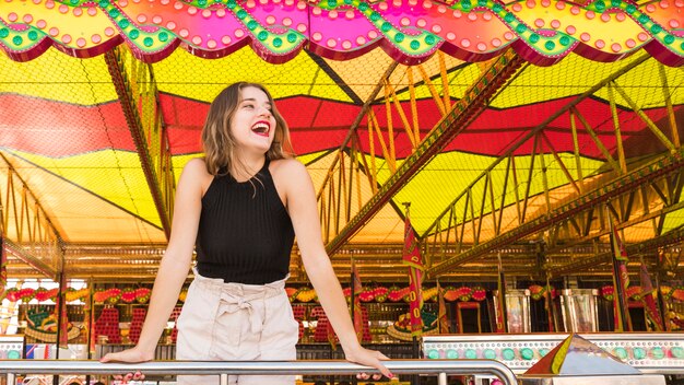 Retrato de una mujer joven que se ríe del parque de atracciones