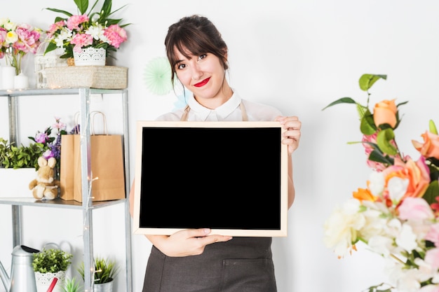 Retrato de una mujer joven que sostiene la pizarra en blanco