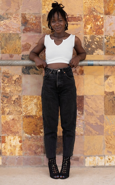 Retrato de mujer joven con rastas afro posando afuera