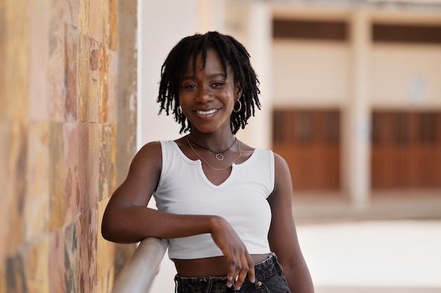 Foto gratuita retrato de mujer joven con rastas afro posando afuera