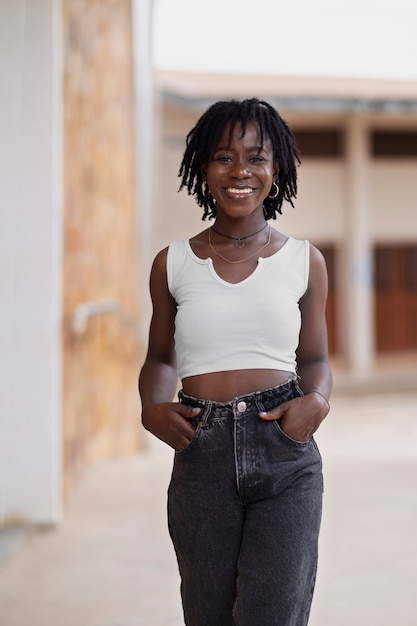Retrato de mujer joven con rastas afro posando afuera