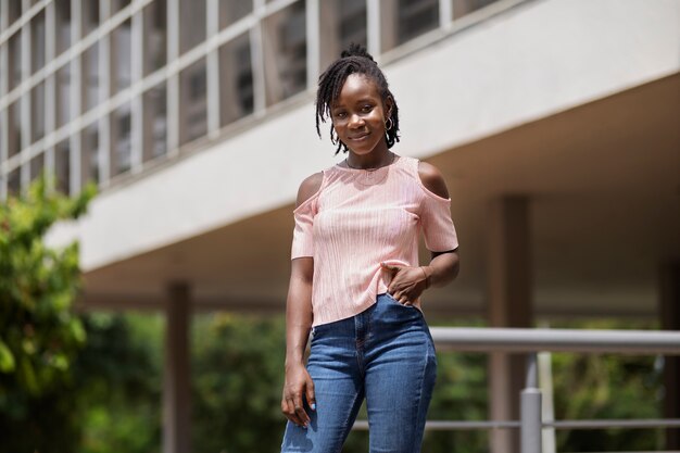 Retrato de mujer joven con rastas afro posando afuera