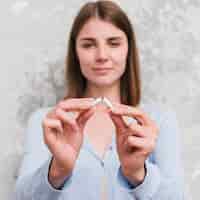 Foto gratuita retrato, de, mujer joven, romper el cigarrillo