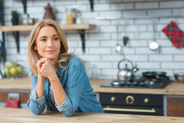 Foto gratuita retrato de mujer joven rubia en la cocina