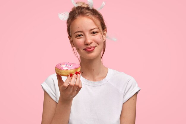 Retrato de mujer joven rubia con donut en mano