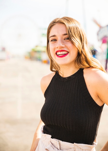 Retrato de mujer joven rubia sonriente con lápiz labial rojo