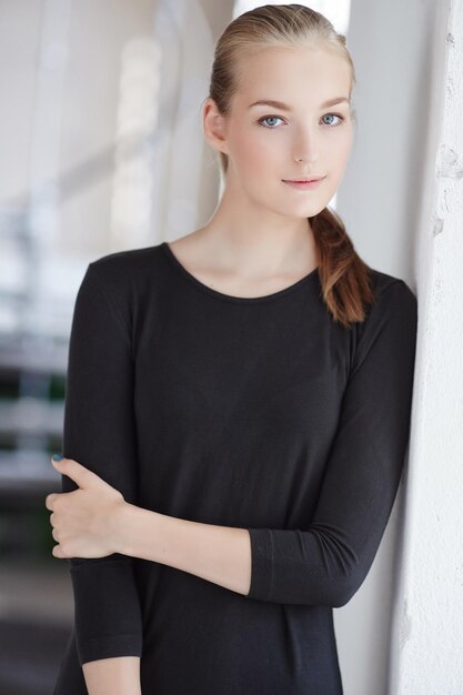 Retrato de mujer joven rubia con un vestido negro.