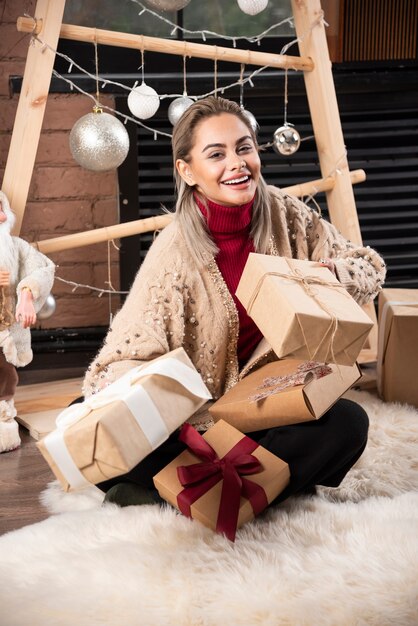 Retrato, de, mujer joven, sentado, y, posar, con, regalos., Foto de alta calidad