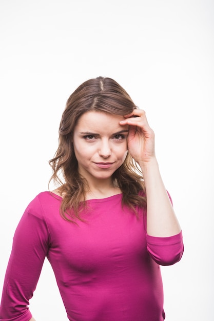 Retrato de una mujer joven smirking sobre fondo blanco