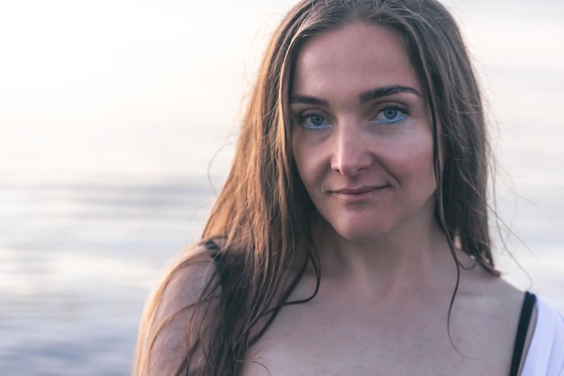 Retrato de una mujer joven sobre un fondo borroso del mar