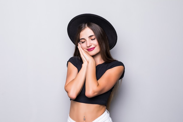 Retrato de mujer joven con sombrero negro sobre fondo gris