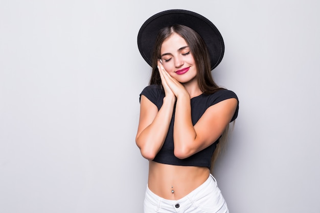 Retrato de mujer joven con sombrero negro sobre fondo gris