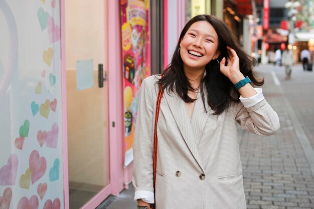 Retrato de mujer joven sonriendo en la calle