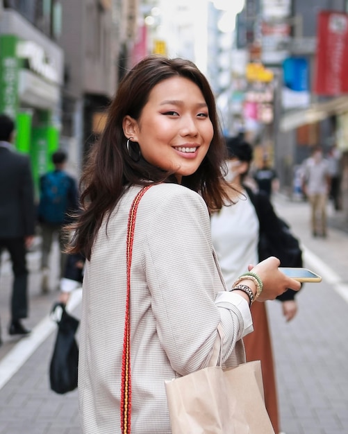 Retrato de mujer joven sonriendo en la calle