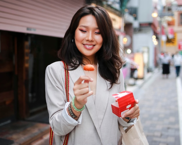 Retrato de mujer joven sonriendo en la calle