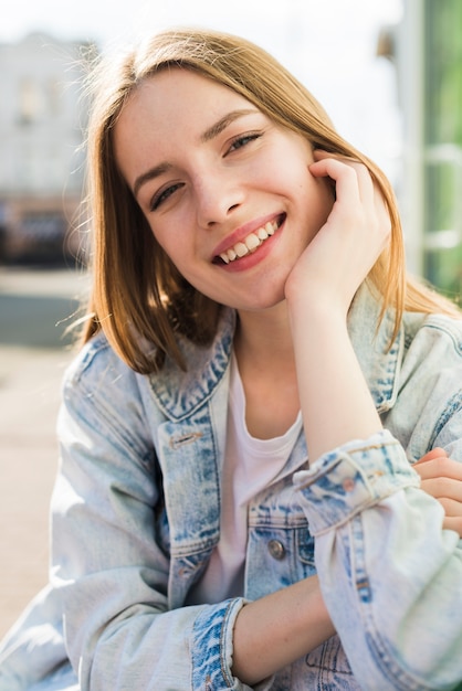 Retrato de la mujer joven sonriente bonita que mira la cámara