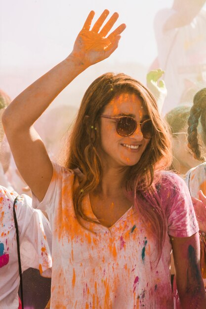 Retrato de una mujer joven sonriente celebrando el festival holi